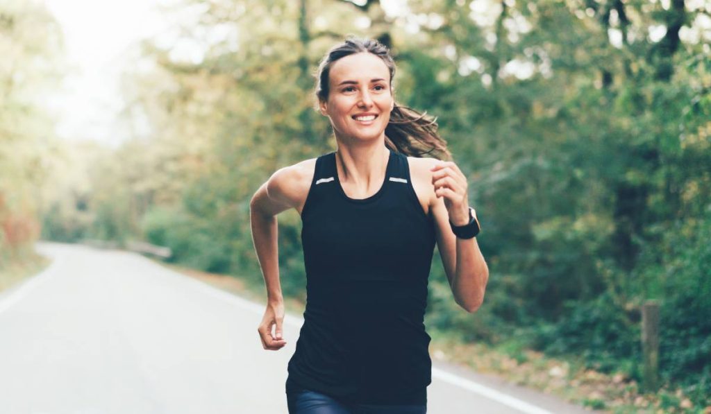 a person running on a road in the middle of the day, which helps with emotional regulation 