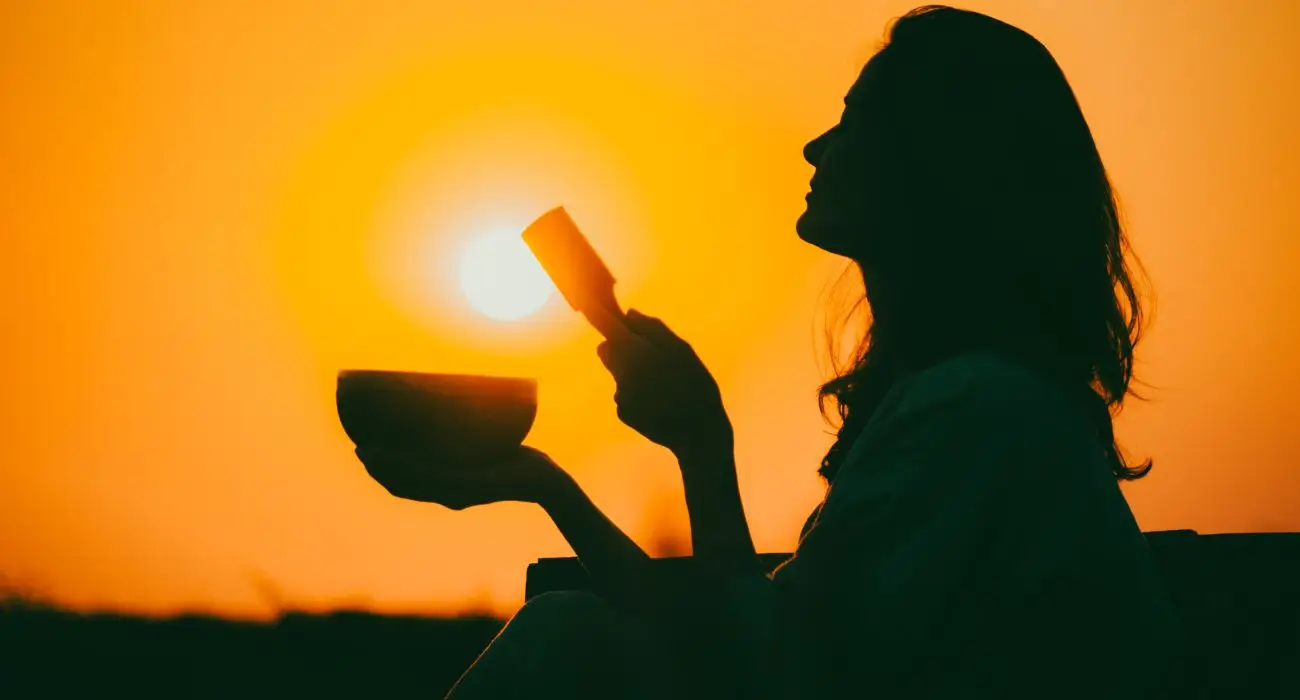 woman changing with a bowl with sun in the background