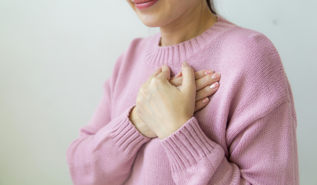 woman putting their hand over their heart