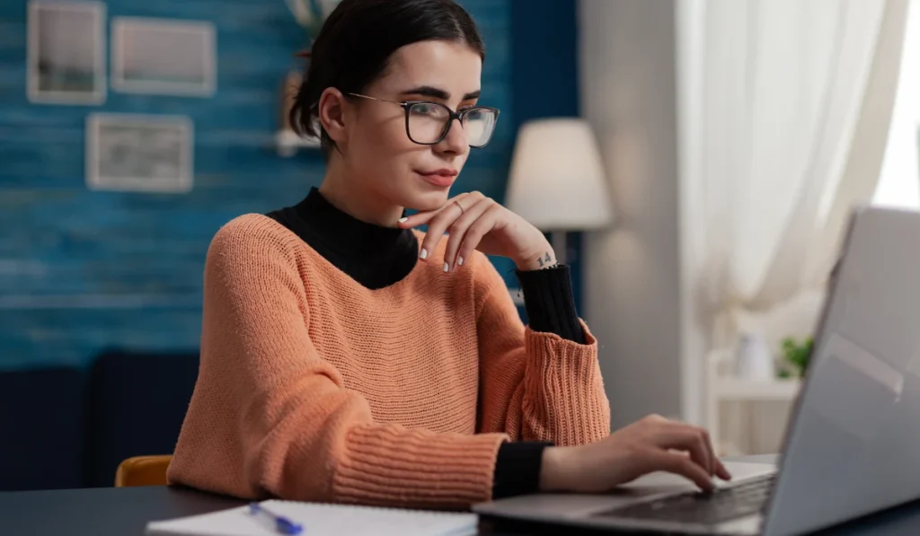 woman attending an online therapy session on her laptop at home